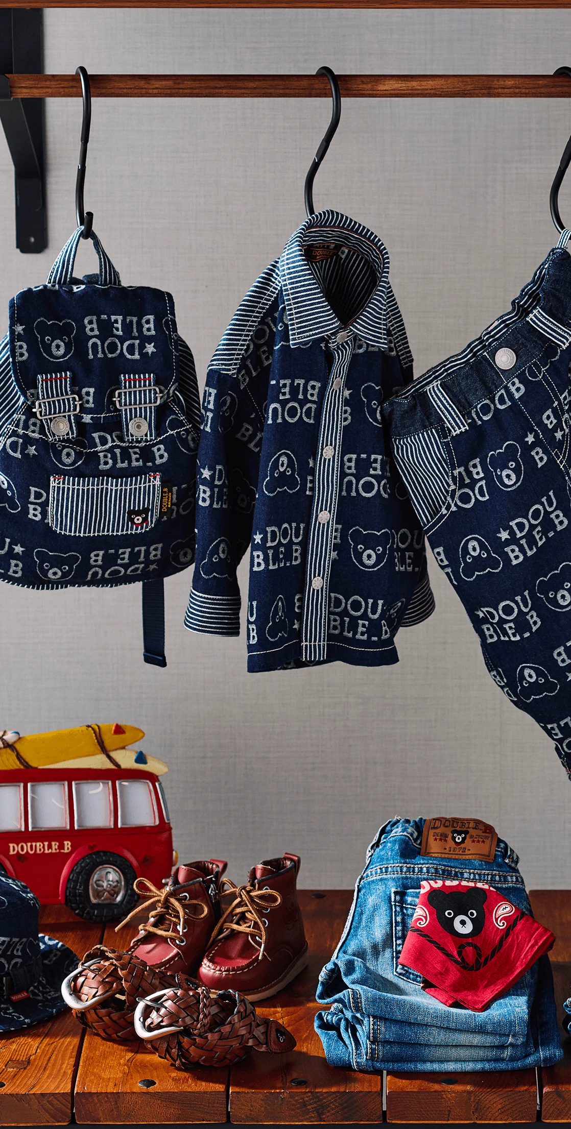 「DOUBLE.B」と描かれたカラフルな帽子とトレーナーを着た子どもが、上を見上げる姿